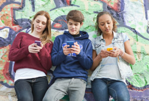 Teenagers using their smartphones simultaneously.